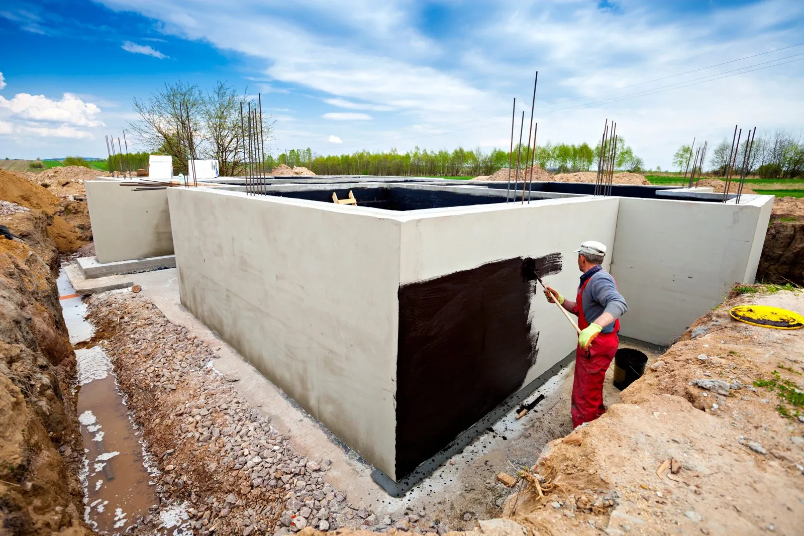 Below-grade waterproofing membrane on a foundation wall, photographed before backfill.