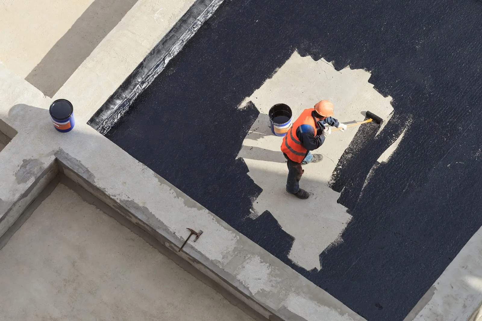 Looking down on a plaza deck where a waterproofing membrane patch is being installed.